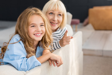 Grandmother showing something to her granddaughter at home