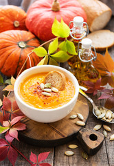 Bowl of pumpkin soup on rustic wooden background