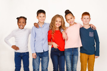 Kids hugging and looking at camera against white background