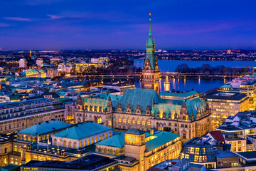 The Hamburg City Hall (German: Rathaus) with downtown and the lake Alster at night. Aerial view.