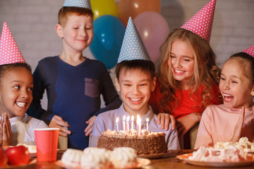 Boy celebrating birthday and making wish at home