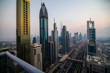 Obraz premium Dubai skyline and downtown skyscrapers on sunset. Modern architecture with highrise buildings on world famous metropolis in United Arab Emirates