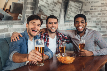 Friends drinking beer and resting in bar