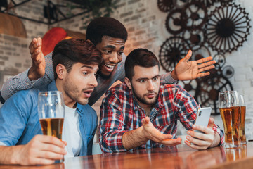 Men watching results of football match on smartphone