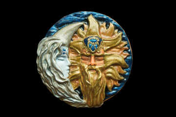 Sun and moon polymer clay handmade jewelry pendant isolated on black