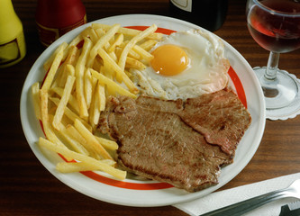 Plato combinado con un Bisteck, un huevo frito y patatas fritas.