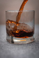 the glass is filled with dark liquid on a gray background