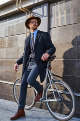 Fototapeta na wymiar handsome stylish male posing with a bicycle in the street