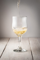 Glass of white wine on vintage wooden table