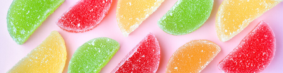 colored jelly slices with sugar crystals, on pink background