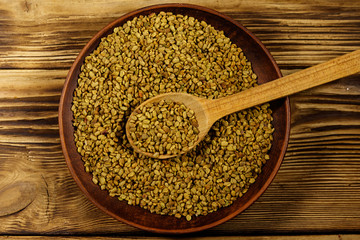 Fenugreek seeds in ceramic plate on wooden table