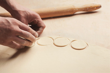 Man forming small circles from raw dough