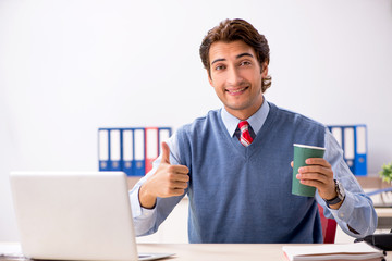 Young handsome employee working in the office 