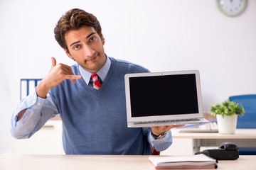 Young handsome employee working in the office 