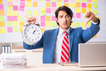 Young handsome employee with many conflicting priorities 
