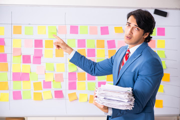 Young handsome employee with many conflicting priorities 