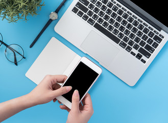 Social network connecting office table concept with fashion accessories, minimal interior with a woman holding smartphone, top view, flat lay, mockup, copy space
