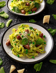 Homemade Pasta with green peas, spinach pesto and sausages. parmesan cheese. healthy food.