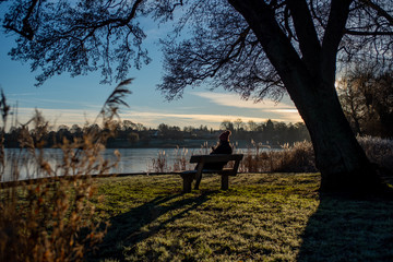 Young girl taking in the view of a frozen lake on a sunny morning in January