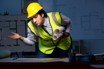 Young construction architect working on project at night 