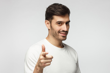 Caucasian male pointing at camera, isolated on grey background