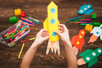 preschool Child in creativity in the home. Happy kid makes rockets from paper. Children's creativity. Creative children play with craft.
Tools and materials for children's art creativity on table.