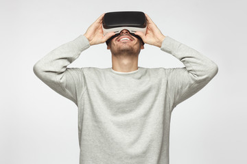 Caucasian male wearing virtual reality goggles and enjoying games