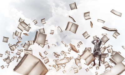 Young man on pile of books dont want to hear anything