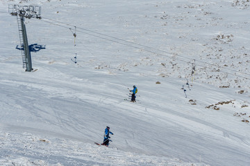 Fototapeta na wymiar People are skiing on snow at a ski resort in the mountains. Winter landscape