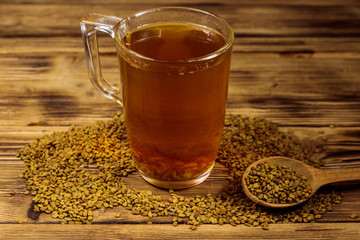 Egyptian yellow tea or Methi Dana drink and fenugreek seeds on wooden table