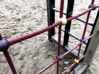 Wooden plank bridge hangs on the chain, sand below, passing, concept for unsafe way