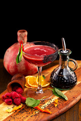 Closeup image of raspberry classic alcohol cocktail at decorated wooden table background.
