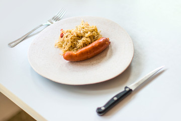 Cabbage with sausages in a plate on the table. Selective focus.