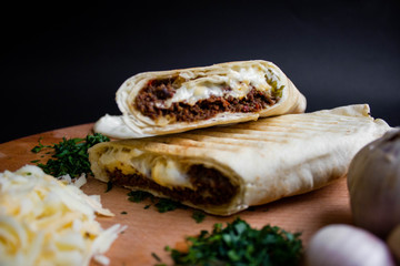 Shawarma sandwich with ingredients on dark background. Top view. sandwich in pita bread. burrito