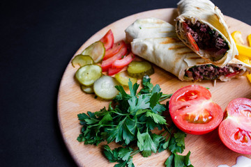 Shawarma sandwich with ingredients on dark background. Top view. sandwich in pita bread. burrito