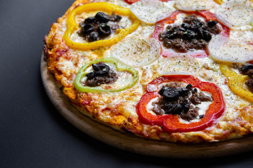 hot tasty delicious rustic homemade american pizza with tomato with thick crust on black table