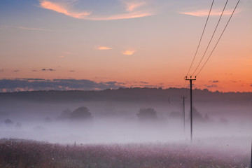 Rural landscape, the wires go into the pink mist,