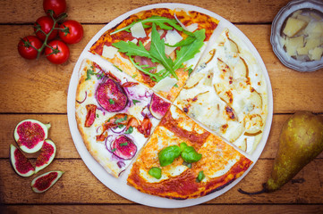 Vier verschiedene Pizzen mit Rucola, Gorgonzola, Birnen, Feigen, Margeritha