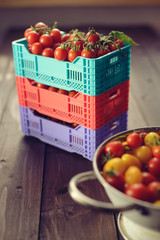 Fresh ripe tomatoes are in the boxes on broun wooden table