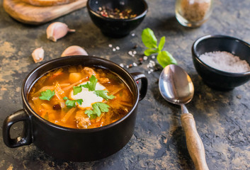 Ukrainian borscht red soup with garlic buns close-up in a bowl on the table.