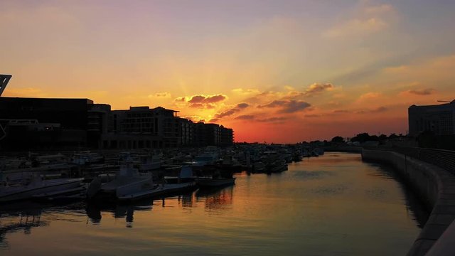 Beautiful relaxing view of city Marina boats and modern apartment buildings at sunset, Abu Dhabi Al Bateen