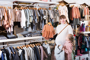Fototapeta na wymiar Pregnant woman examining baby's clothes