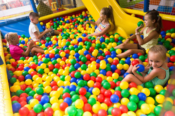 Fototapeta na wymiar Group of kids playing on playground with plastic balls