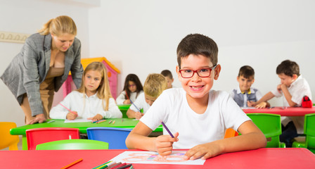 Diligent schoolboy drawing at lesson