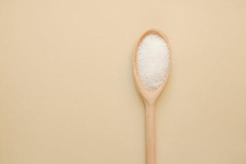 Sugar in a wooden spoon. Top view with copy space