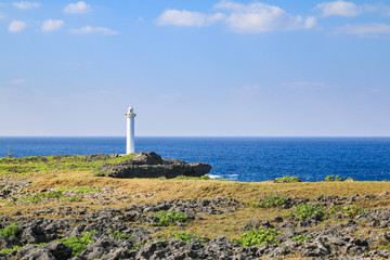Fototapeta na wymiar white lighthouse in cape zanpa with blue sea and sky