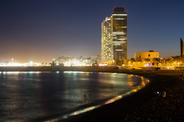 Barceloneta beach with Mapfre tower and Arts Hotel in night