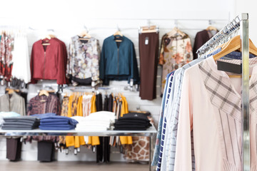 Many stylish clothes on hangers and shelfs