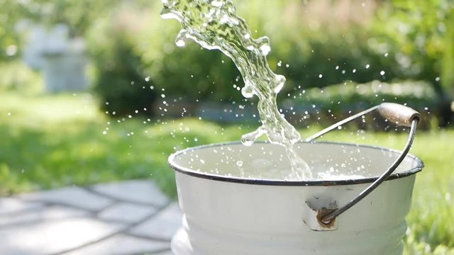 Pouring the water into metal bucket, 1920x1080 footage, closeup