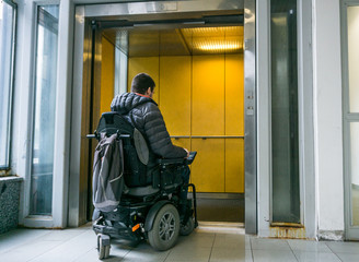 Handicapped male on wheelchair going in elevator © 24K-Production